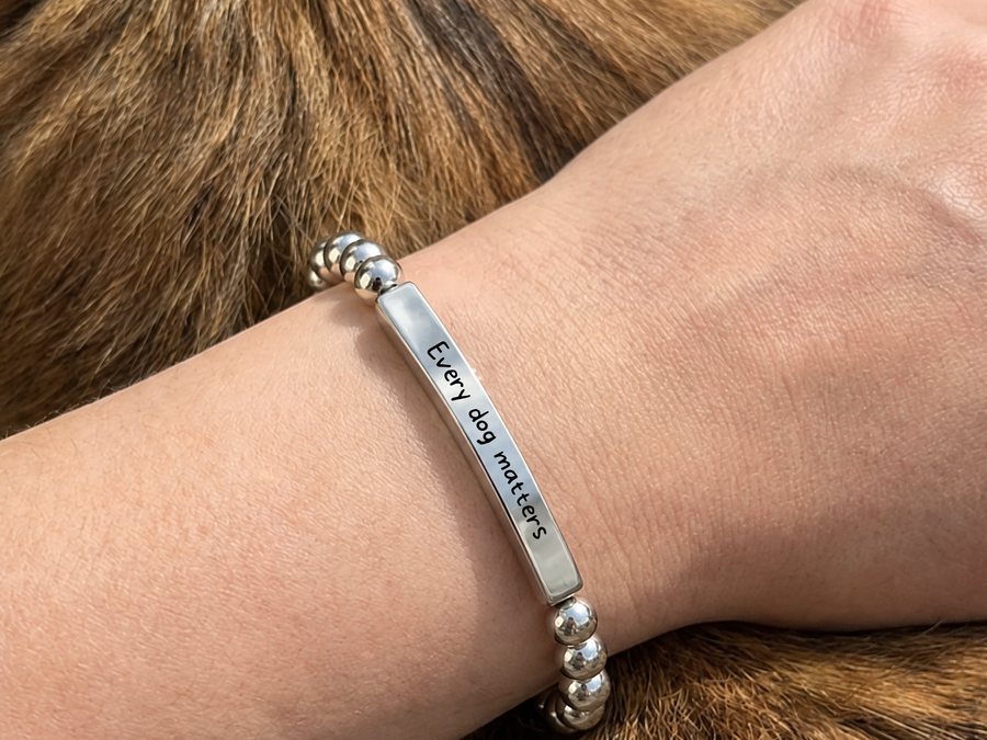A wrist wearing a Rescue Paws message bracelet