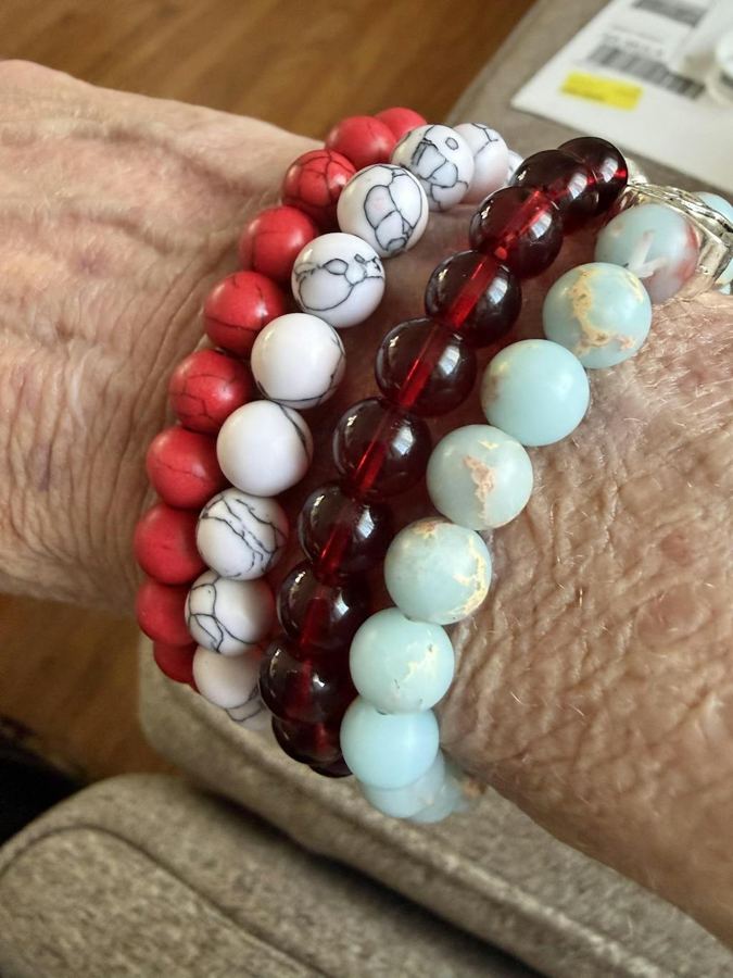 Customer photo from a verified Judge.me review of the Arctic Bracelet: four Rescue Paws bracelets stacked on her wrist