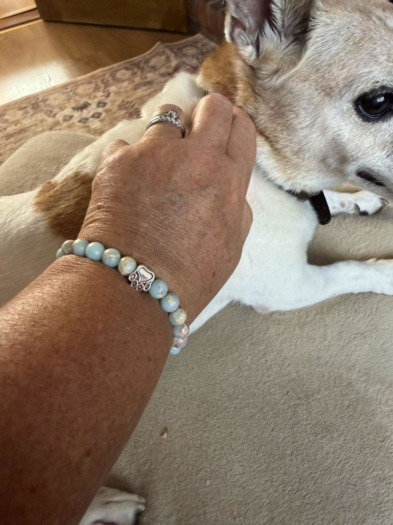 Customer photo from a verified Judge.me review of the Pearl Bracelet: a dog sniffing the bracelet on its owner's wrist