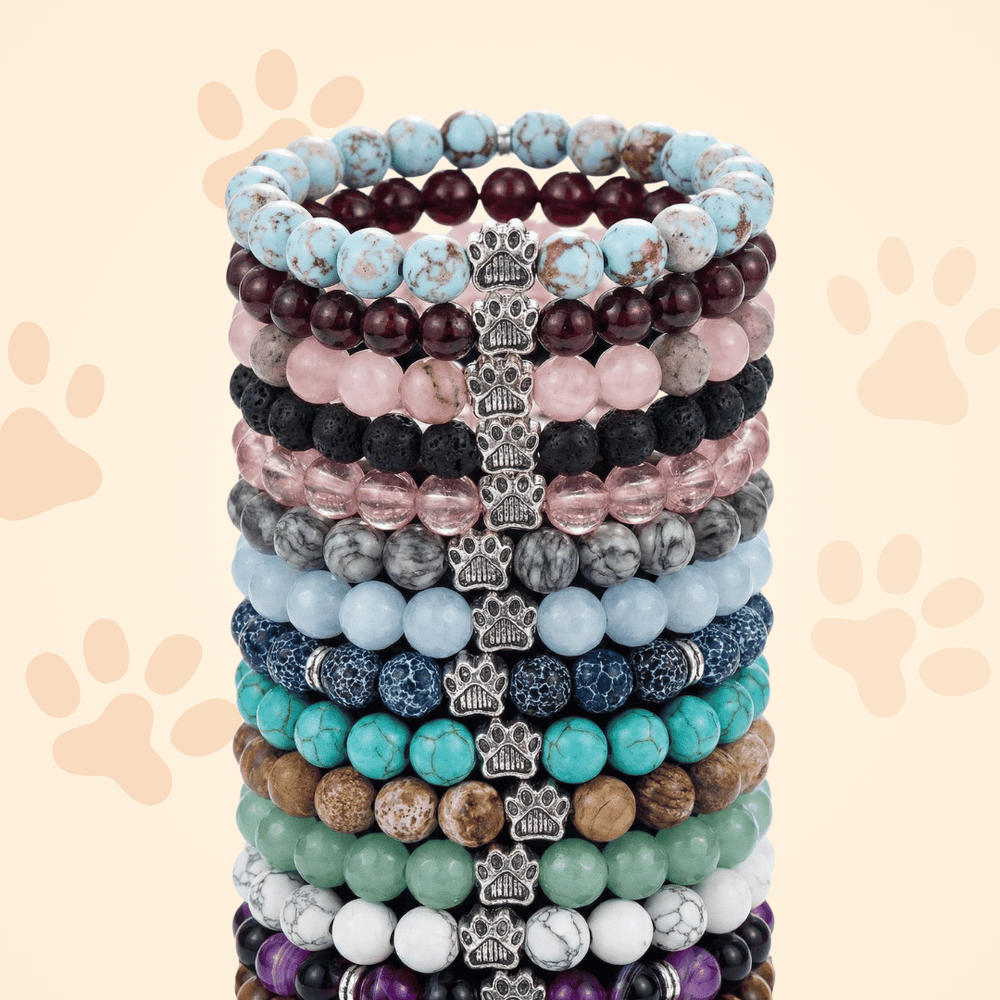 A tall stack of Rescue Paws beaded bracelets in many colors, each with a silver paw bead