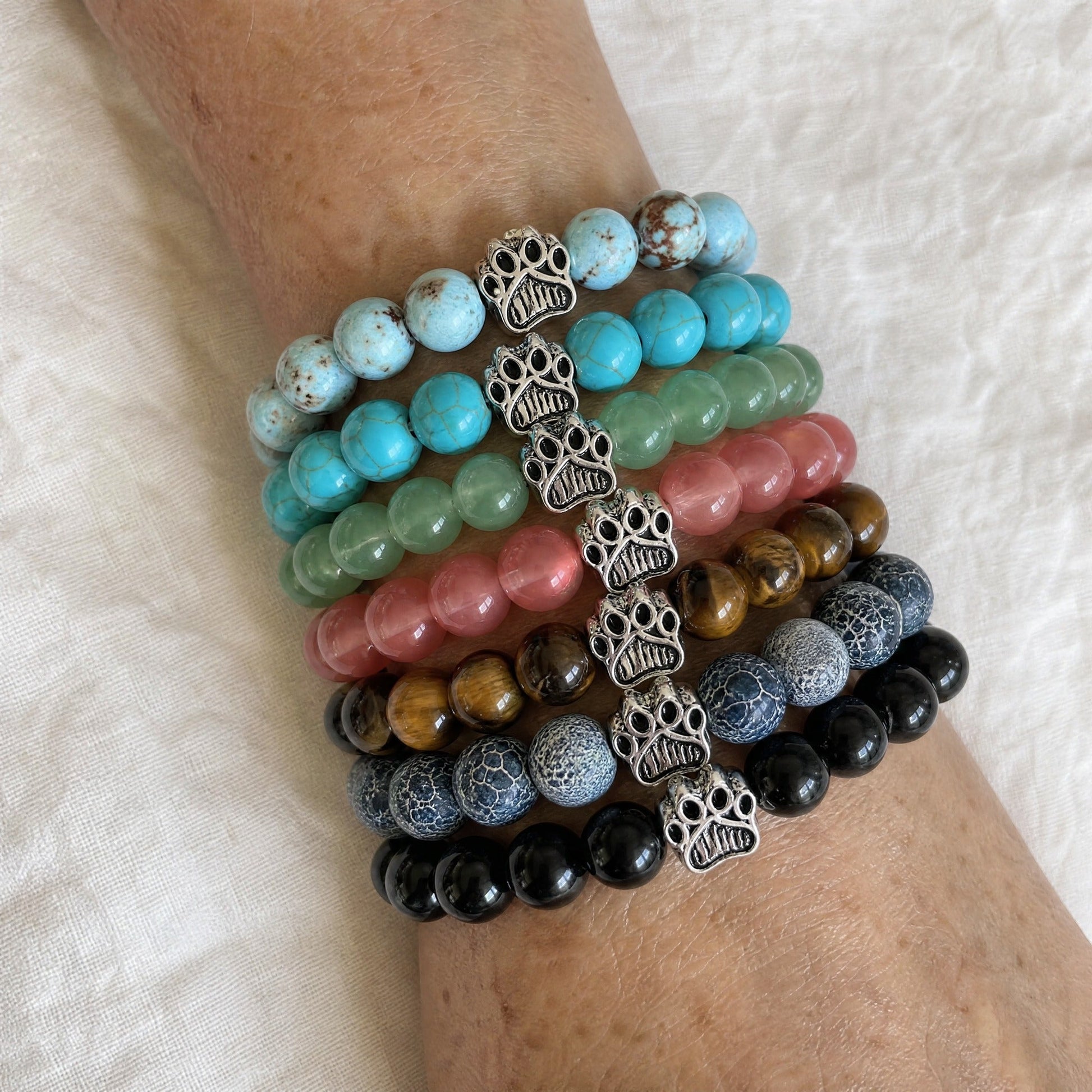 Seven Rescue Paws bracelets from the Bestsellers set stacked and worn on a wrist