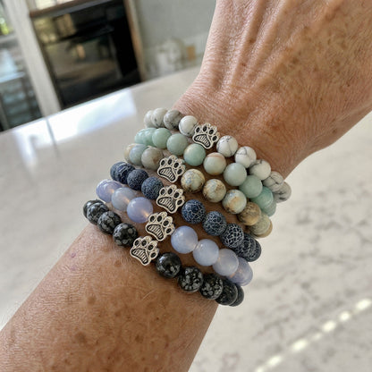 Six Rescue Paws bracelets from the Full Collection stacked and worn on a wrist