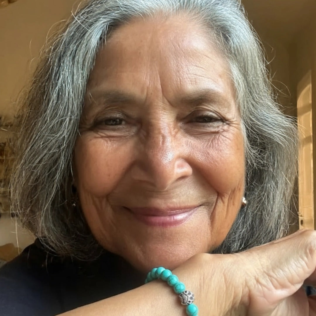 A smiling woman wearing a turquoise Rescue Paws bracelet