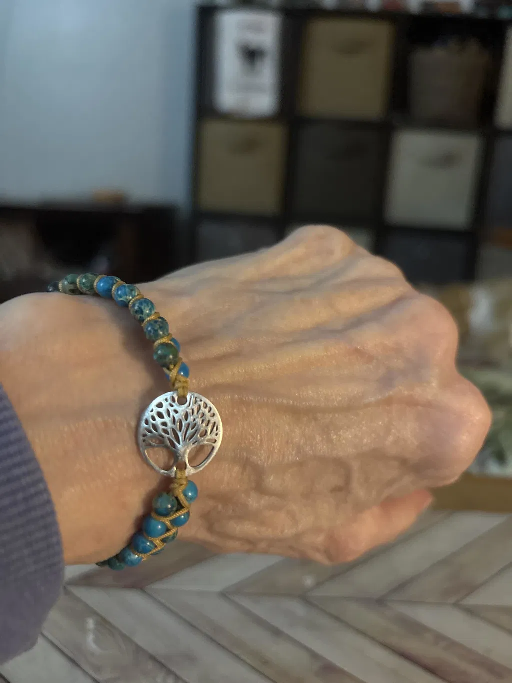 Tree charm bracelet worn on the wrist