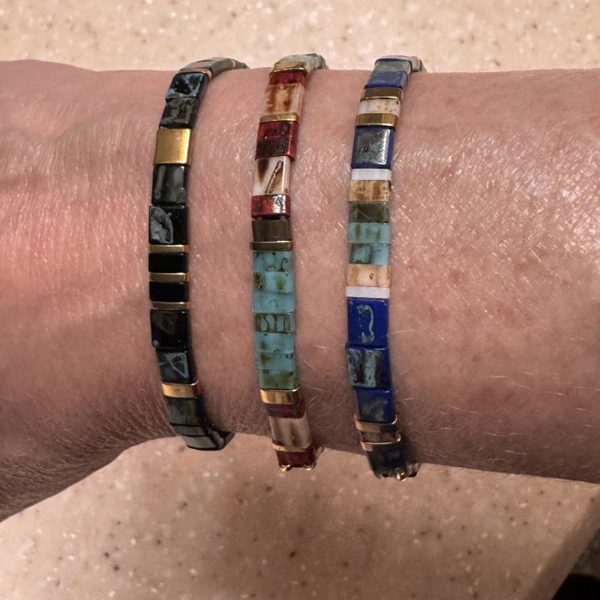 A customer's wrist with three Rescue Paws Miyuki bracelets