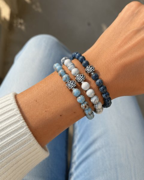 Una muñeca con un set de tres pulseras de cuentas de Rescue Paws